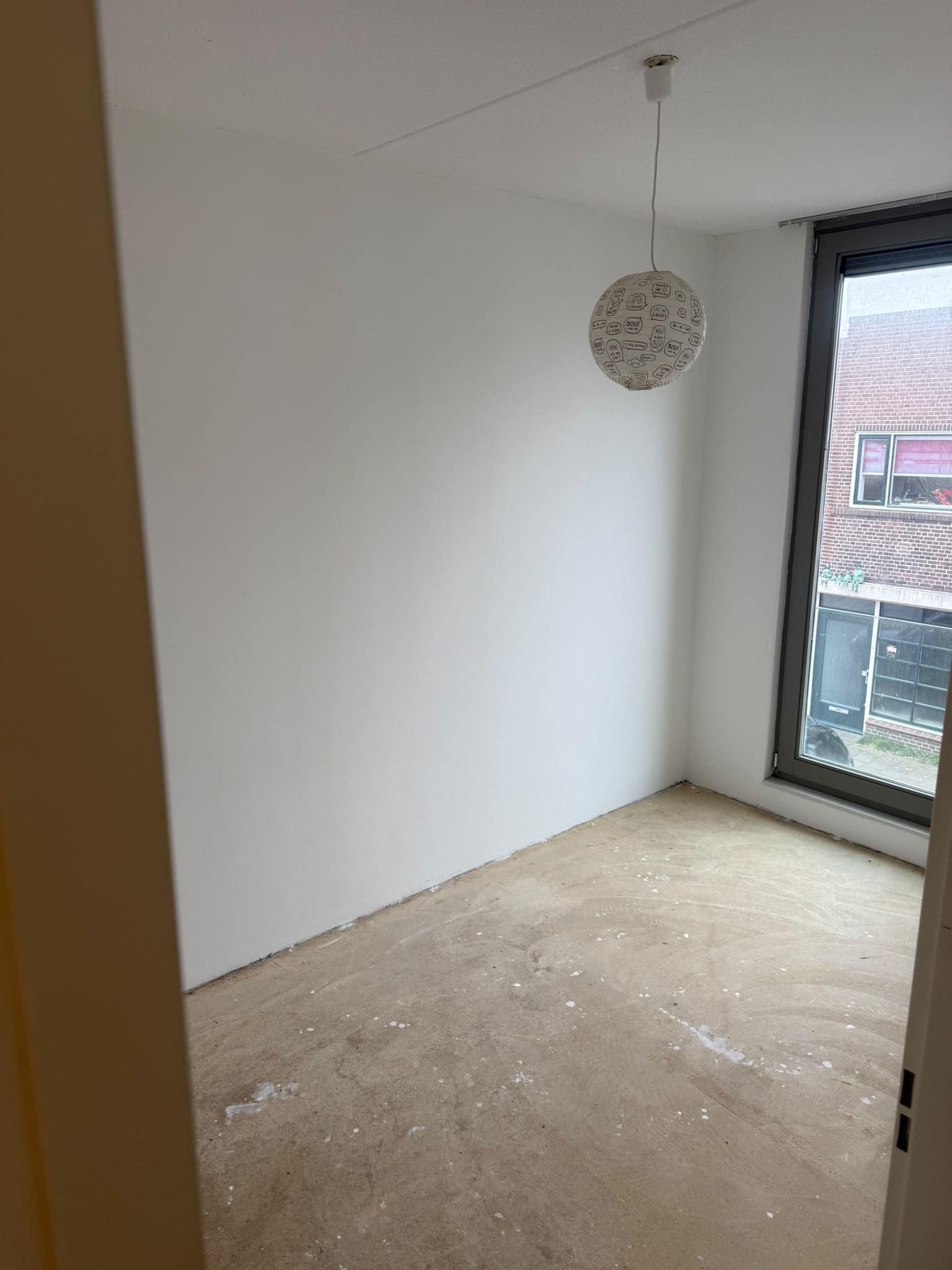 Lege slaapkamer met verse witte wanden en een hanglamp aan het plafond